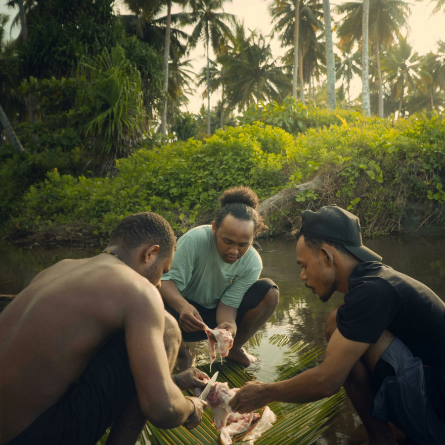 a group of men standing next to each other near a river
