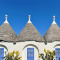 a house with blue doors and a roof with a blue door with Alberobello in the background
