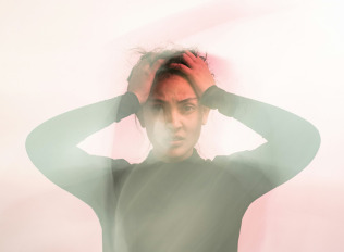 man sitting on gang chair with feet on luggage looking at airplane