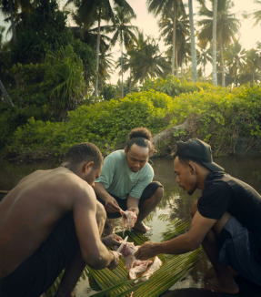 a group of men standing next to each other near a river