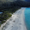 an aerial view of a beach and a forested area in Tasmania