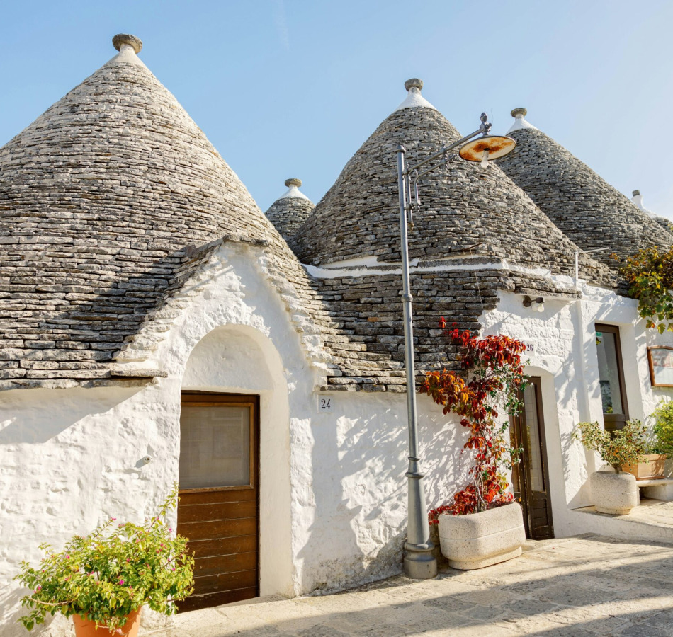 a house with blue doors and a roof with a blue door with Alberobello in the background