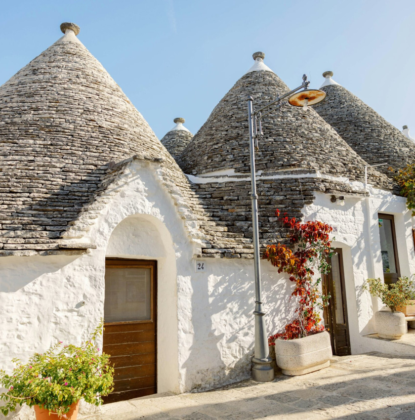 a house with blue doors and a roof with a blue door with Alberobello in the background