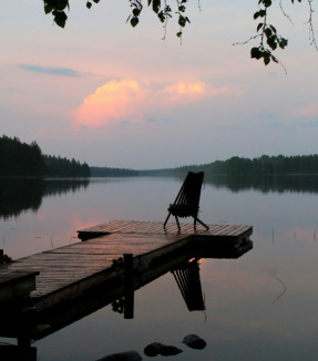 brown wooden bench on dock near lake during daytime