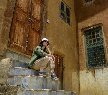 a man sitting on steps in front of a building