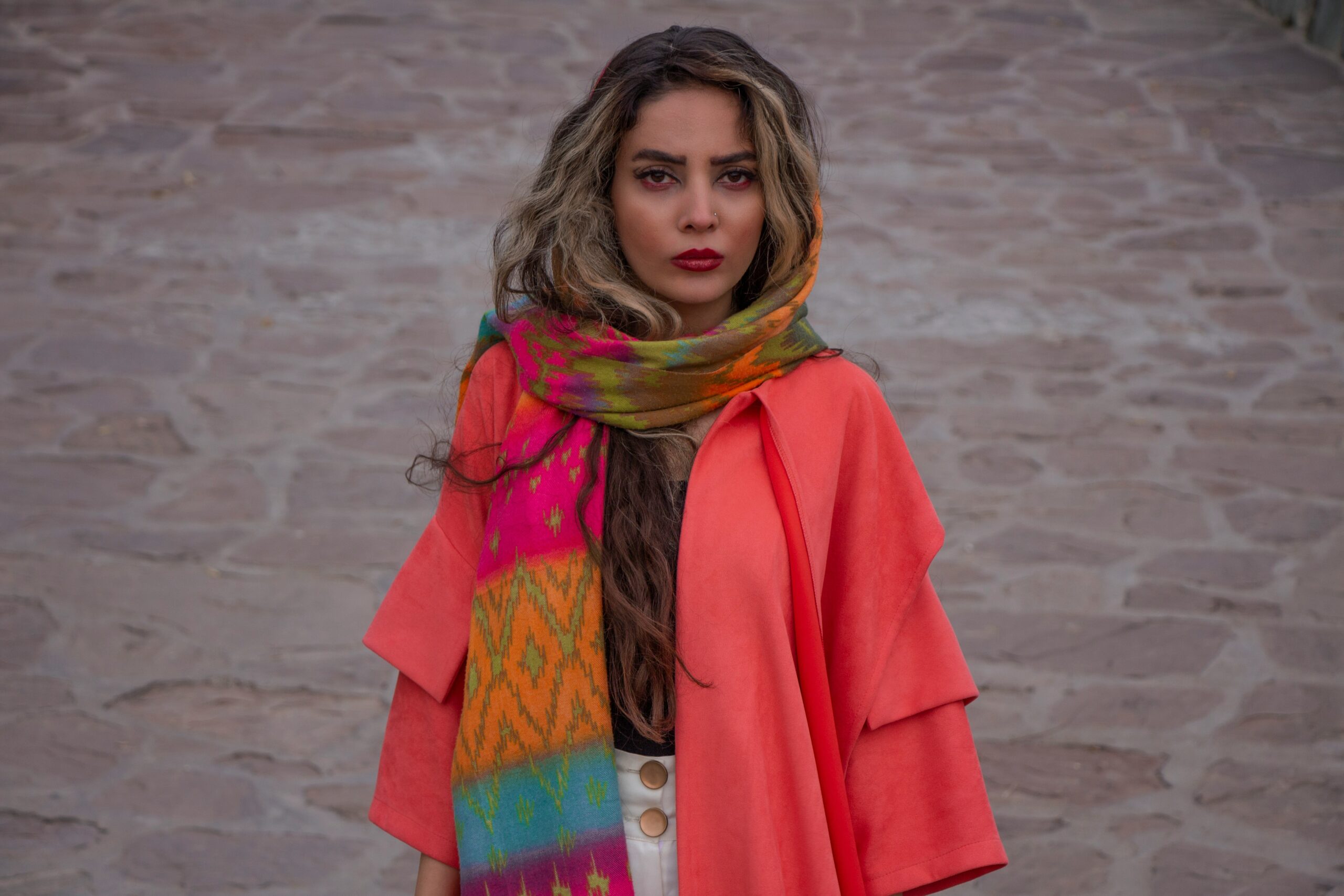 woman in red coat standing on white sand during daytime