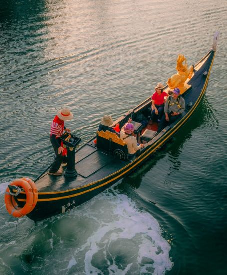 A gondola glides through the water with passengers aboard.